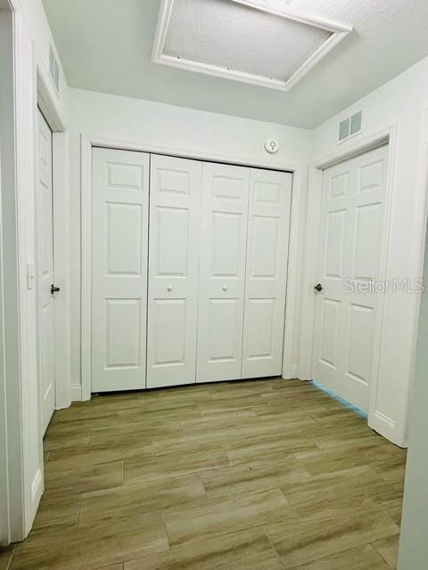 unfurnished bedroom with a closet and light hardwood / wood-style floors