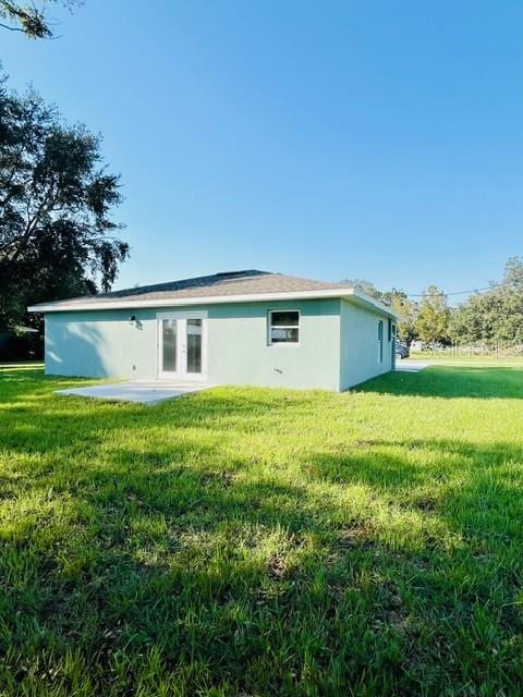 rear view of property featuring a yard