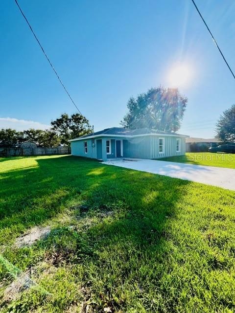 view of front of property featuring a front lawn and a patio