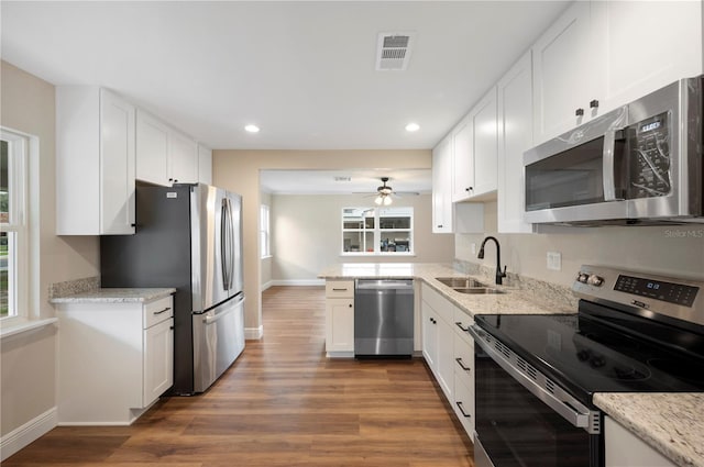 kitchen featuring white cabinets, sink, stainless steel appliances, dark hardwood / wood-style floors, and light stone countertops