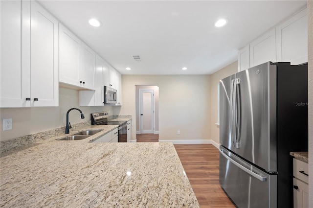 kitchen featuring stainless steel appliances, light wood-type flooring, sink, and white cabinetry