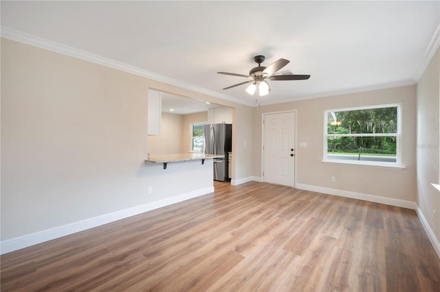 unfurnished living room featuring crown molding, light hardwood / wood-style floors, and a wealth of natural light