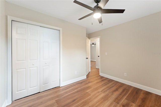 unfurnished bedroom featuring a closet, light wood-type flooring, and ceiling fan