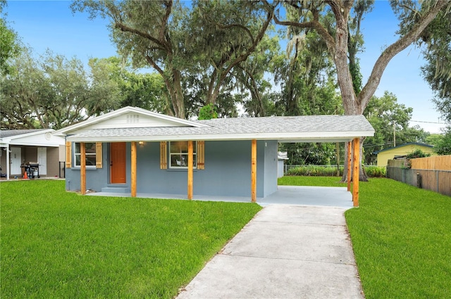 ranch-style home featuring a front lawn, covered porch, and a carport