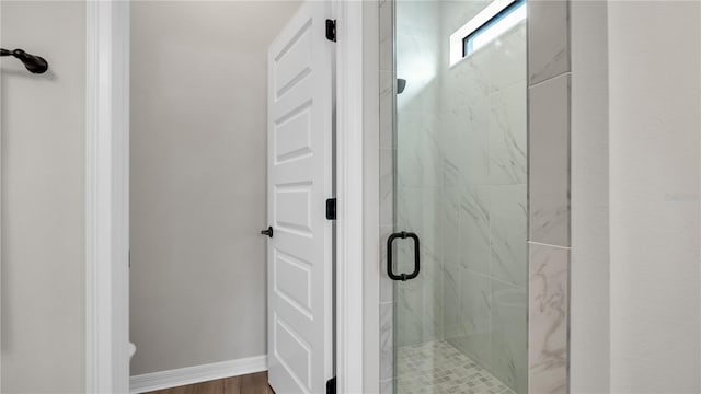 bathroom featuring wood-type flooring and a shower with door