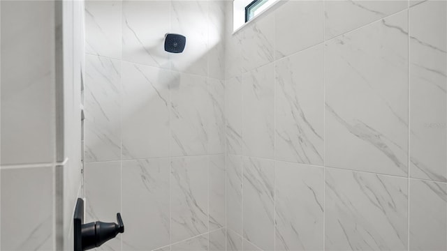 interior details with a tile shower