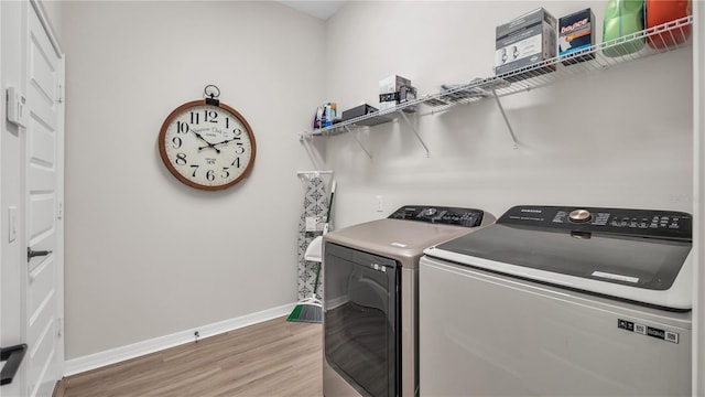 clothes washing area featuring hardwood / wood-style flooring and independent washer and dryer