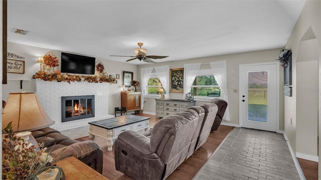 living room featuring ceiling fan and a fireplace