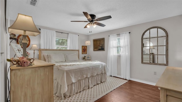 bedroom with wood-type flooring, a textured ceiling, and ceiling fan