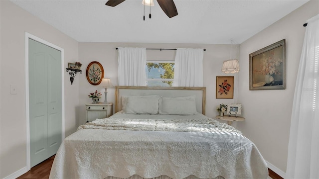 bedroom featuring dark hardwood / wood-style flooring, ceiling fan, and a closet