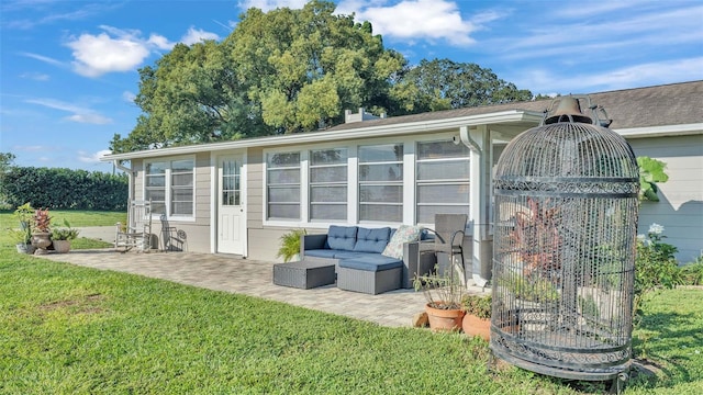 rear view of house featuring a yard and a patio