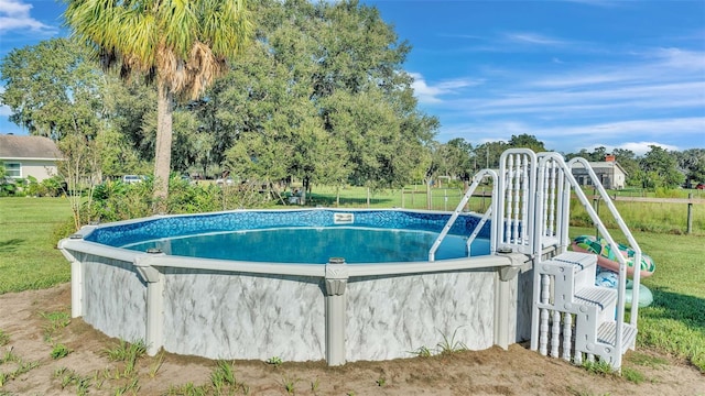 view of pool featuring a lawn