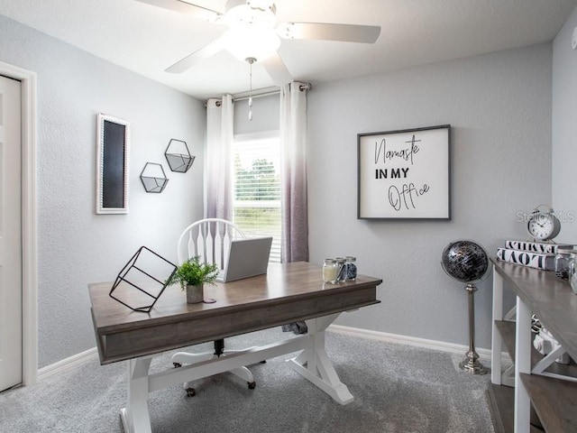 carpeted home office featuring ceiling fan