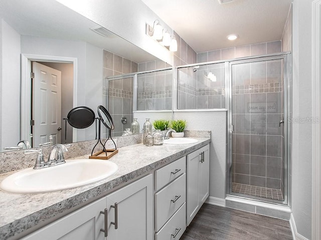 bathroom with hardwood / wood-style flooring, an enclosed shower, and vanity