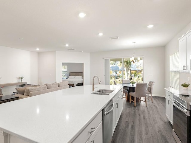 kitchen featuring a center island with sink, white cabinetry, sink, and stainless steel appliances