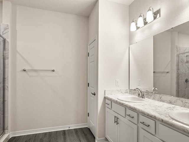 bathroom with vanity, wood-type flooring, and a shower with shower door