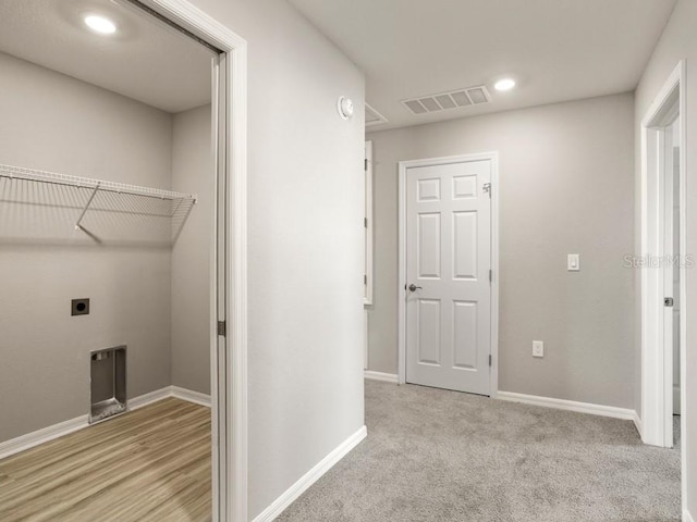 washroom with hookup for an electric dryer and light hardwood / wood-style floors