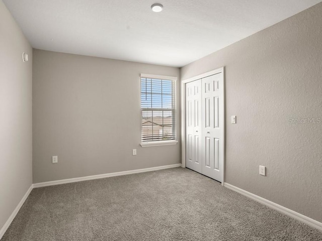 unfurnished bedroom with carpet floors and a closet