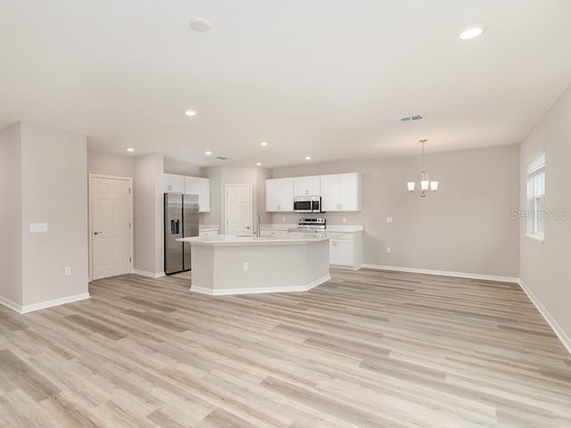 unfurnished living room with an inviting chandelier and light wood-type flooring