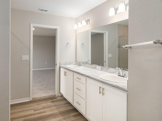 bathroom with vanity, hardwood / wood-style floors, and a shower with door