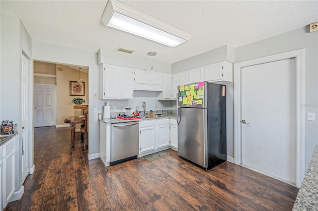 kitchen featuring a textured ceiling, white cabinets, stainless steel appliances, and dark hardwood / wood-style flooring