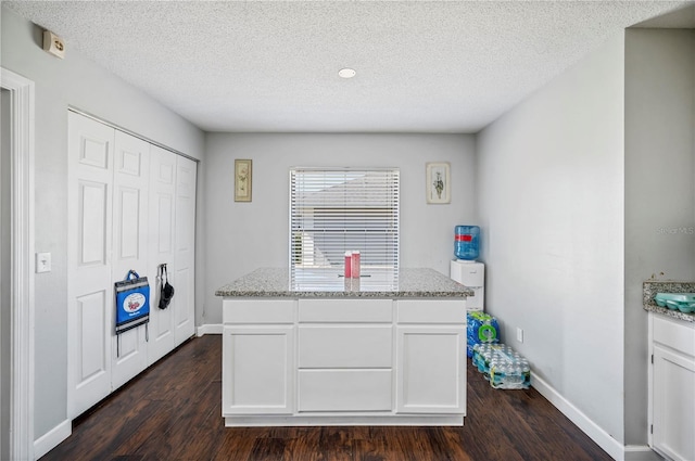 941 Devonshire Way, Lake Wales, FL 33853 - kitchen featuring dark wood finished floors, white cabinets, baseboards, light stone counters, and a textured ceiling