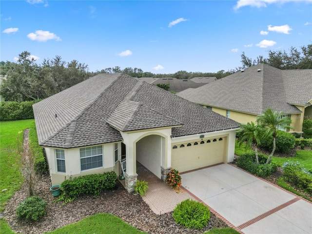 view of front of home featuring an attached garage, a shingled roof, stucco siding, and driveway