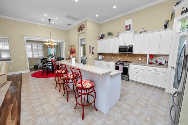 kitchen featuring crown molding, stainless steel appliances, a breakfast bar area, and white cabinets