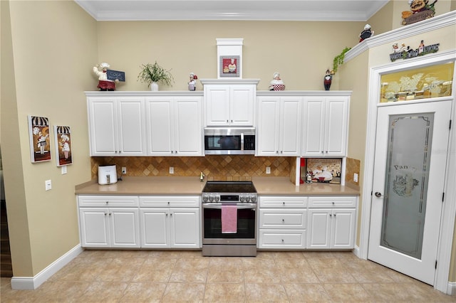 kitchen featuring appliances with stainless steel finishes, light tile patterned flooring, backsplash, white cabinets, and ornamental molding