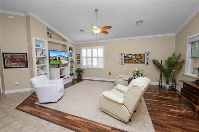 living room with ceiling fan, hardwood / wood-style flooring, vaulted ceiling, built in shelves, and crown molding