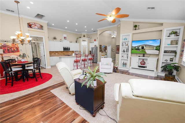 living room featuring ornamental molding, lofted ceiling, light wood-type flooring, and ceiling fan with notable chandelier