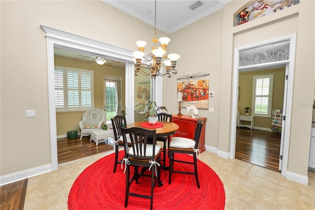 dining area with ceiling fan with notable chandelier, light tile patterned floors, baseboards, ornamental molding, and visible vents