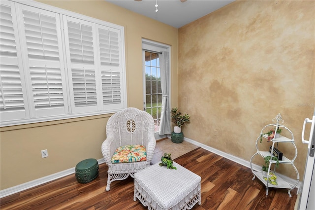 living area featuring dark wood-type flooring and ceiling fan