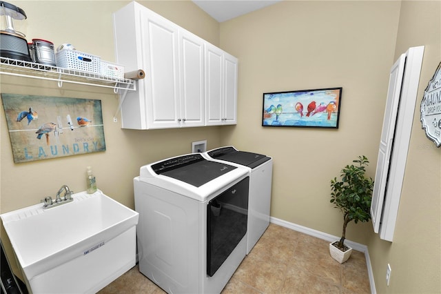 washroom featuring a sink, light tile patterned flooring, baseboards, independent washer and dryer, and cabinet space