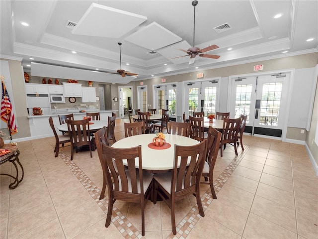 tiled dining room featuring ornamental molding, french doors, a tray ceiling, and ceiling fan