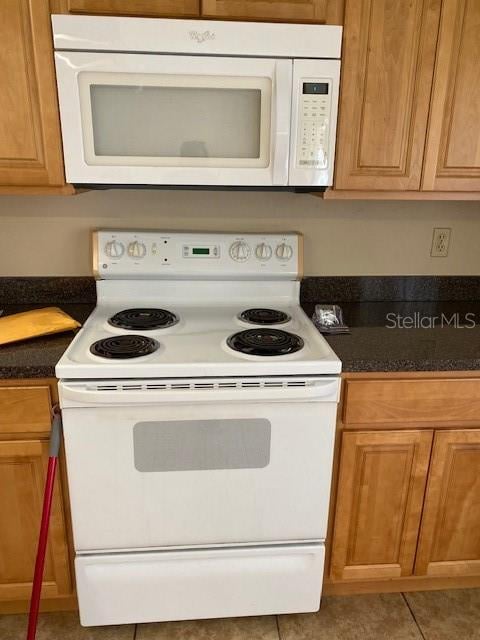 kitchen with light tile patterned floors and white appliances