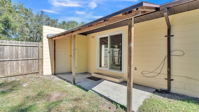 doorway to property featuring fence and a patio