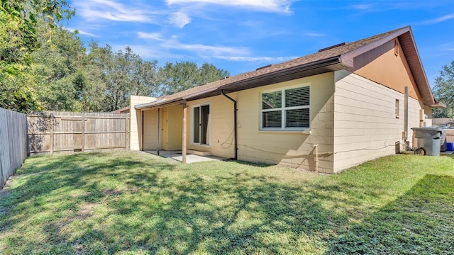 rear view of house with a yard, a patio area, and a fenced backyard