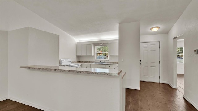 kitchen featuring a peninsula, electric range, dark wood-type flooring, and white cabinets