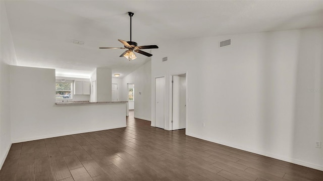 unfurnished living room with a ceiling fan, dark wood-style flooring, visible vents, and baseboards