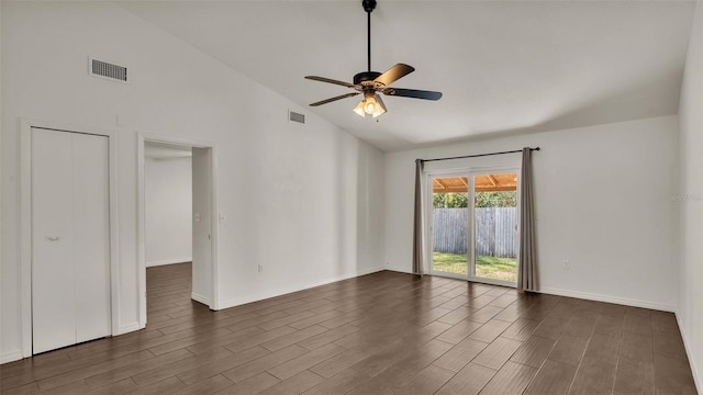 spare room featuring a ceiling fan, dark wood-style flooring, visible vents, and baseboards