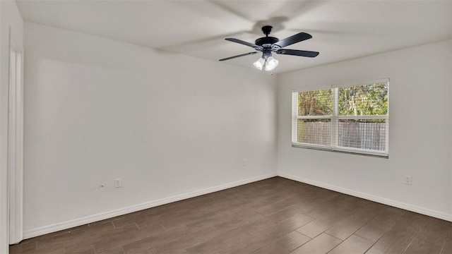 spare room featuring dark wood-style floors, ceiling fan, and baseboards