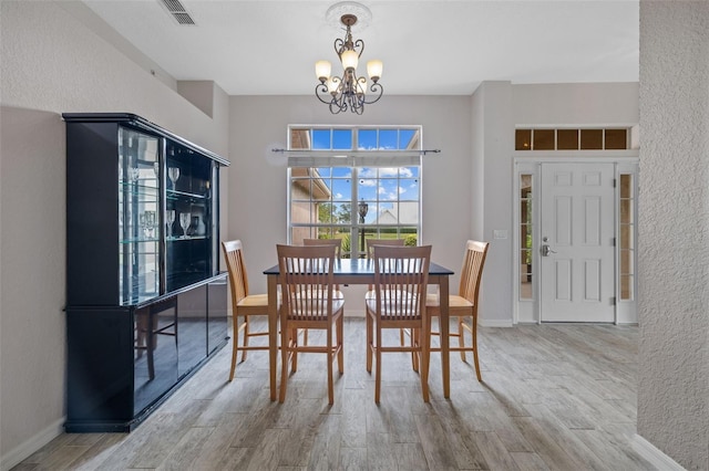 dining room featuring light hardwood / wood-style floors and a chandelier