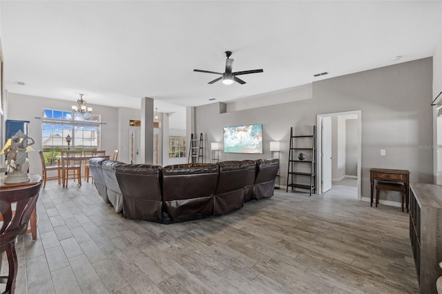 living room with wood-type flooring and ceiling fan with notable chandelier