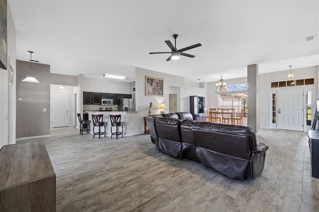 living room featuring hardwood / wood-style floors and ceiling fan with notable chandelier