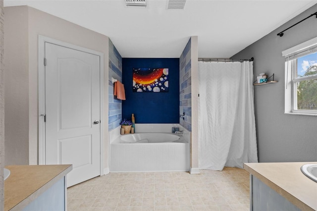 bathroom featuring vanity and tiled bath