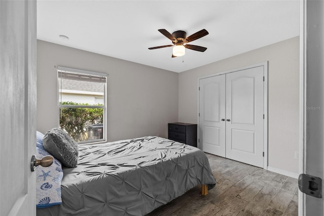 bedroom with a closet, wood-type flooring, and ceiling fan