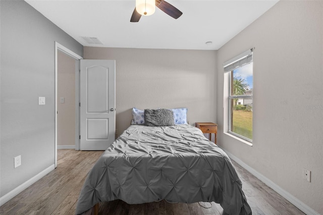 bedroom with light hardwood / wood-style flooring and ceiling fan