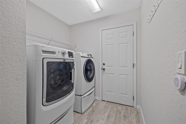 laundry room featuring light hardwood / wood-style flooring and washer and clothes dryer