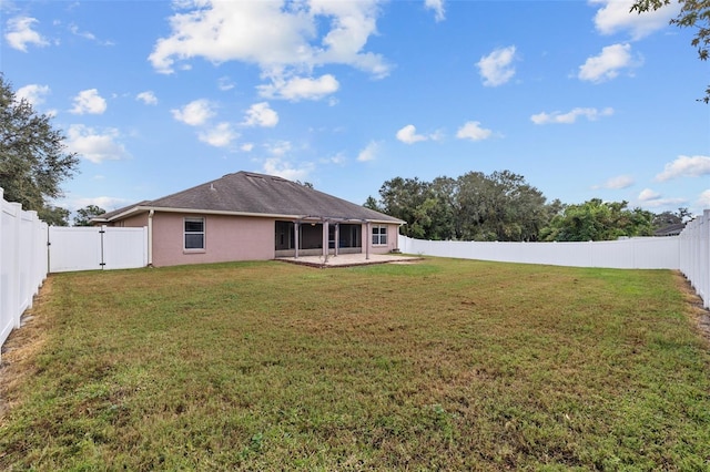 rear view of house with a yard and a patio